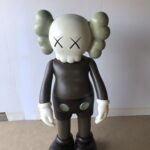 A KAWS Companion figure with a skull-like head, X-ed out eyes, and a brown body.