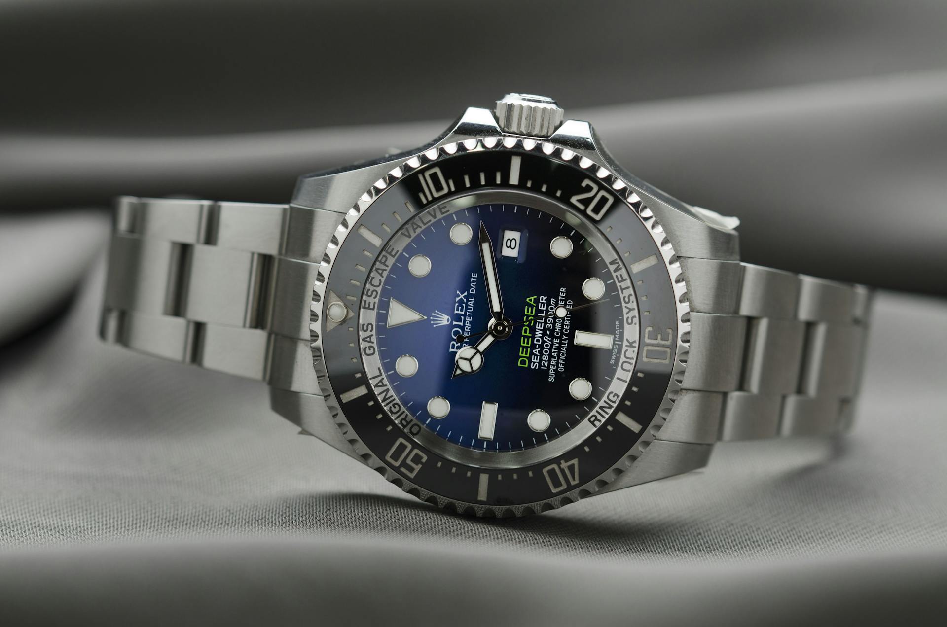 A close-up of a Rolex Deepsea Sea-Dweller watch with a blue dial and stainless steel band.