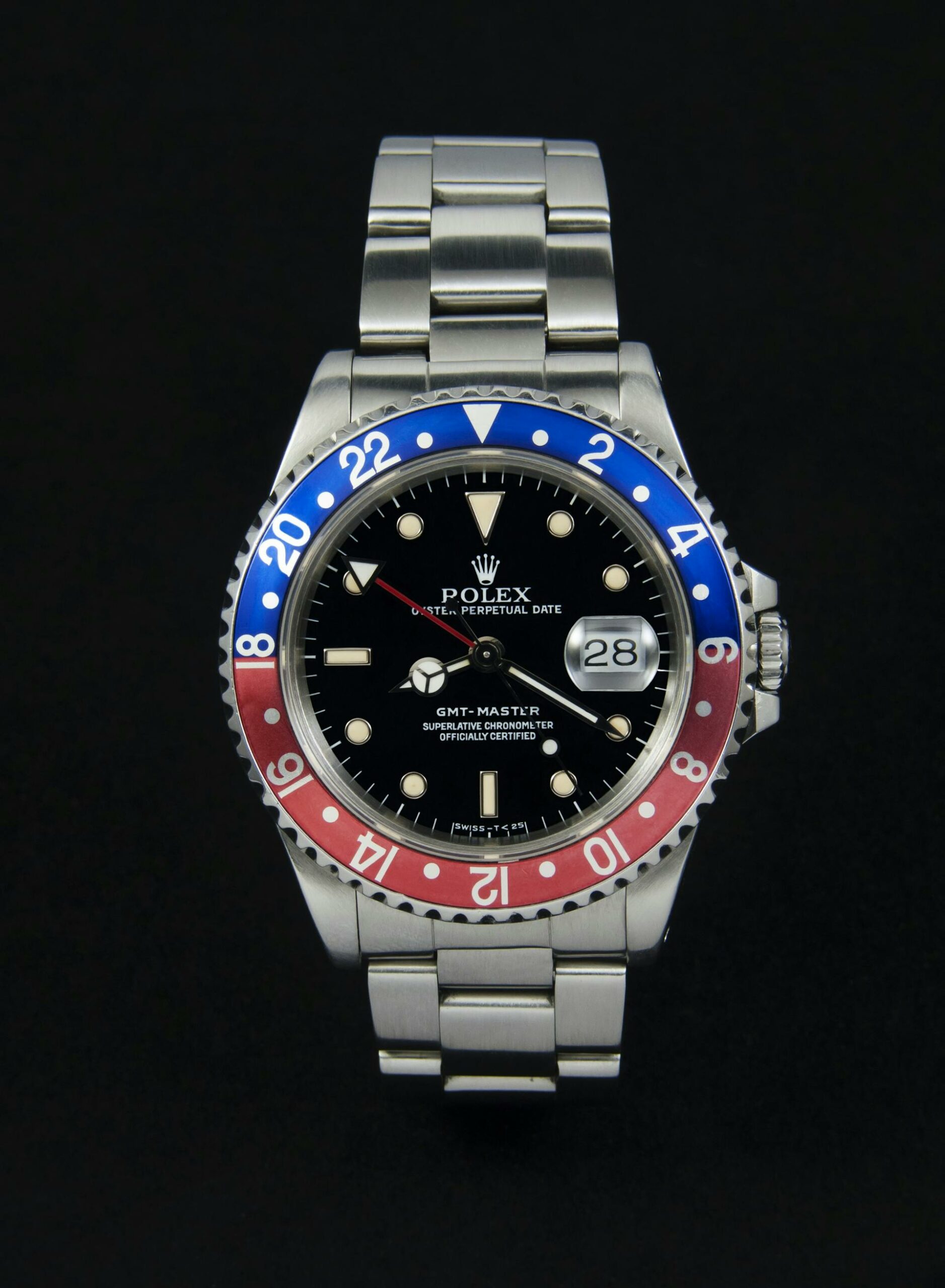 A close-up of a Rolex GMT-Master II watch with a black dial and a red and blue 'Pepsi' bezel.