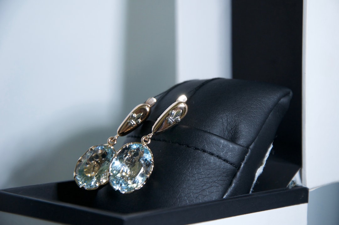 Baccarat-crystal-luxury-collection-asset - borro Drop earrings with large blue gemstones on a black display stand.