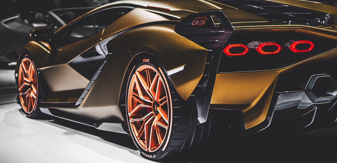 Lamborghini-vs-ferrari-2026-comparison - borro - borro Gold sports car rear view with orange alloy wheels and distinctive red taillights in a showroom setting