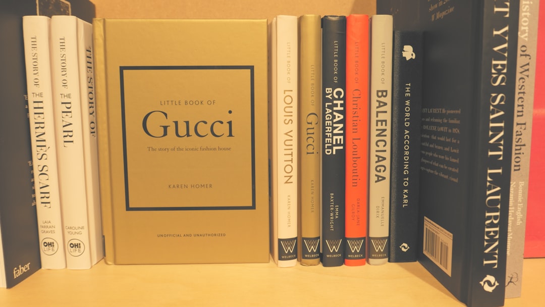 Louis-vuitton-vs-gucci-resale-collateral-value - borro - borro Shelf of fashion books with a central gold box titled 'little book of gucci' by karen homer on display