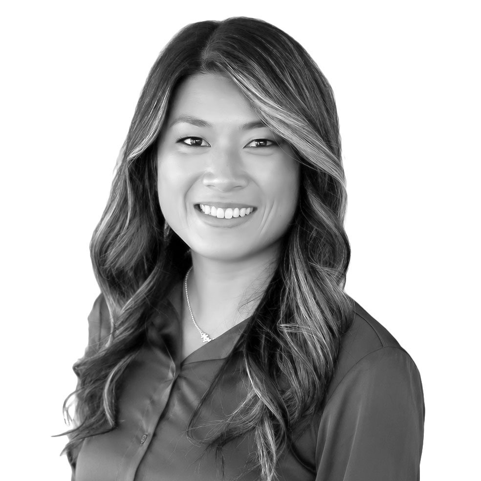 Portrait of a smiling professional woman with long wavy hair.